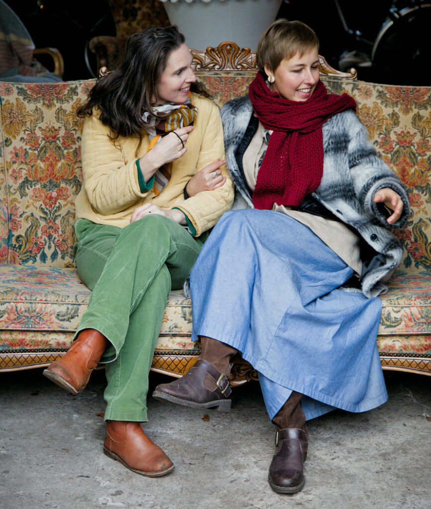 Kim Jacob en Anke Turelinckx samen in een retro bloemetjes zetel bij Tuintaferelen in Arendonk.